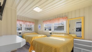 A room with two beds, a white desk, a mirror, and a window with a view of buildings. - Short walk to Beach, 2 Bedroom/1 Bath Quad 2 (down) pool access near Main St (North Myrtle Beach)