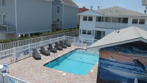 A swimming pool with lounge chairs, a lifeguard tower, and a mural of a whale. - Short walk to Beach, 2 Bedroom/1 Bath Quad 3 (up) w/pool access near Main St (North Myrtle Beach)