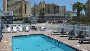 A swimming pool with lounge chairs and a white fence. - Short walk to Beach, 2 Bedroom/1 Bath Quad 4 (up) w/pool access near Main St (North Myrtle Beach)