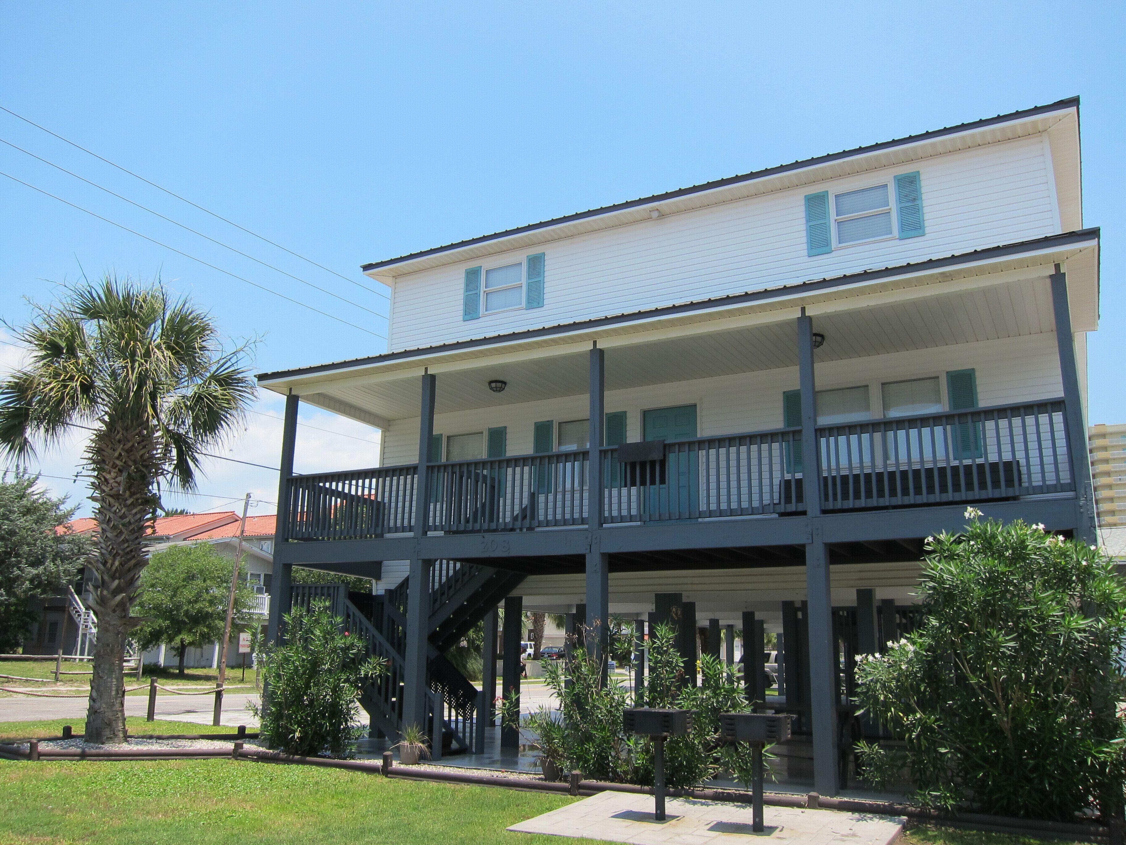 A two-story building with a balcony and a covered porch.