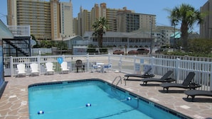 A swimming pool with lounge chairs and a white fence. - Short walk from beach, 5 Bedroom/3 Bath Duplex-10-plenty of room for groups (North Myrtle Beach)
