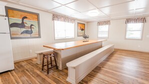 A kitchen with wooden flooring, a white refrigerator, a wooden counter, and two barstools. - Short walk from beach, 5 Bedroom/3 Bath Duplex-10-plenty of room for groups (North Myrtle Beach)