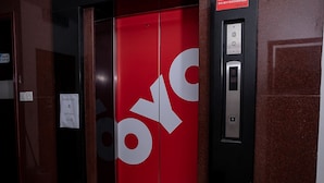 Un ascenseur à l’intérieur rouge, orné d’un grand logo « OYO ».