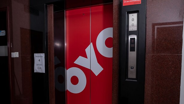 An elevator with a red interior and a large 'OYO' logo. - OYO 90055 Mansion Inn (Sibu)