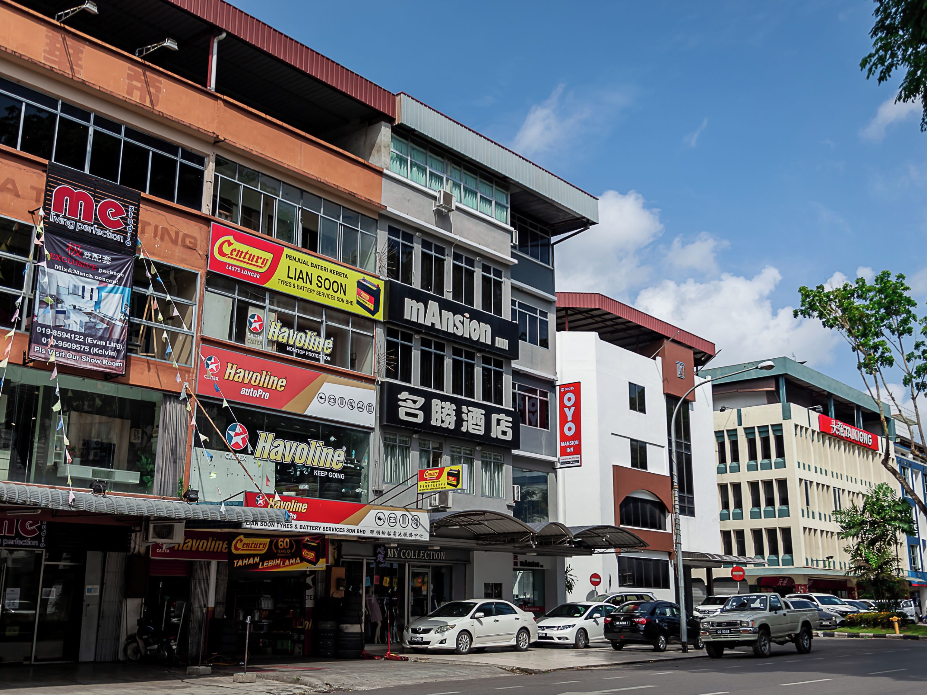 A multi-story commercial building with various storefronts, including automotive service shops and a hotel.