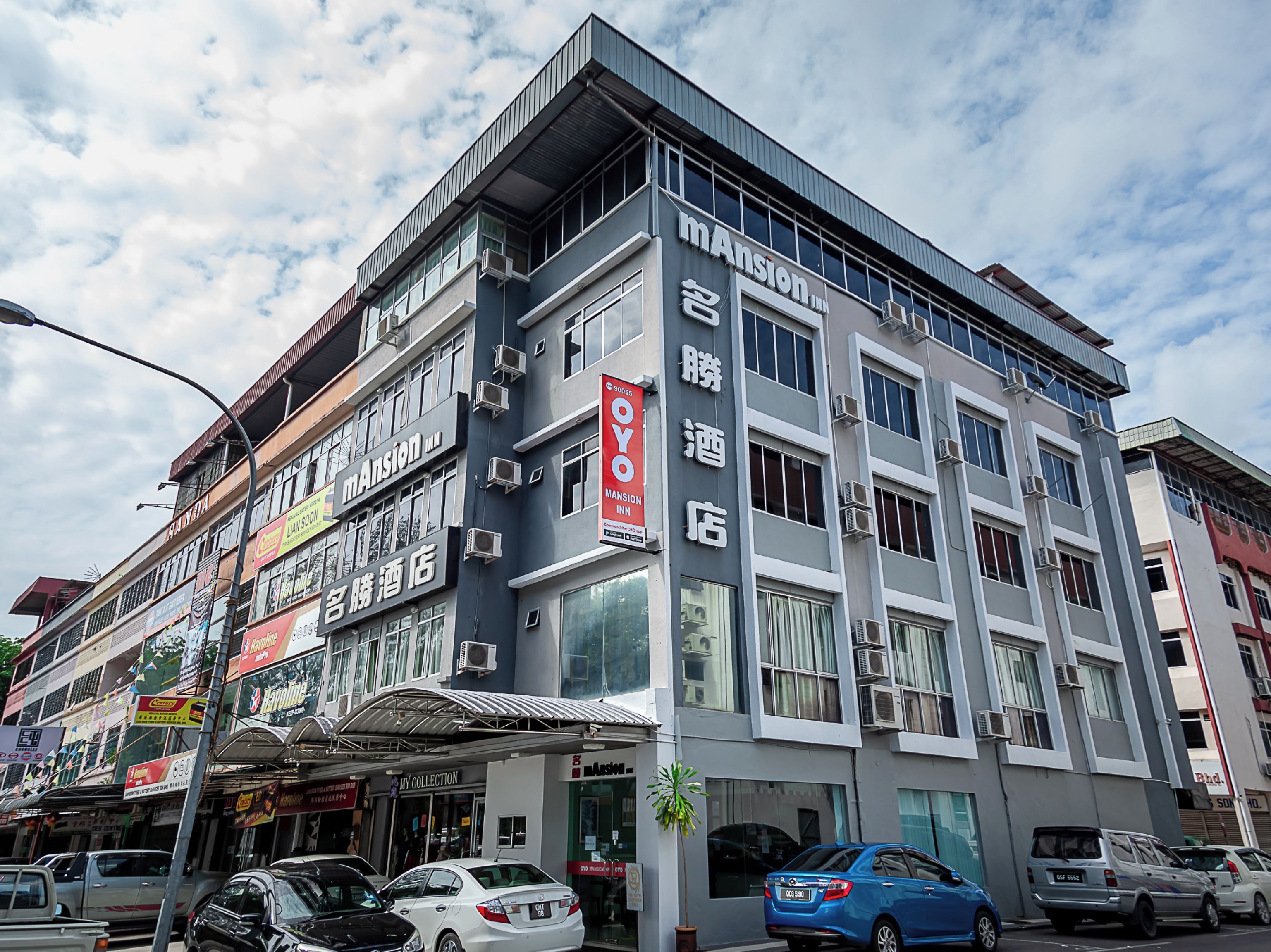 A multi-story hotel with signage for 'mAson Inn' and 'OYO Hotel'.