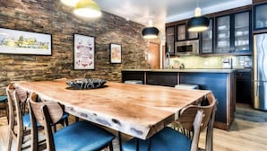 A modern kitchen with a large island, wooden chairs, and pendant lighting. - SPECTACULAR SKI IN - SKI OUT Golf Hiking Biking Casino Chalet in Mont Tremblant  (Mont-Tremblant)