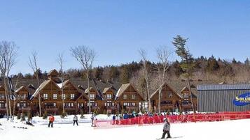 Un chalet comprenant plusieurs cabanes en bois et un grand bâtiment avec une enseigne.