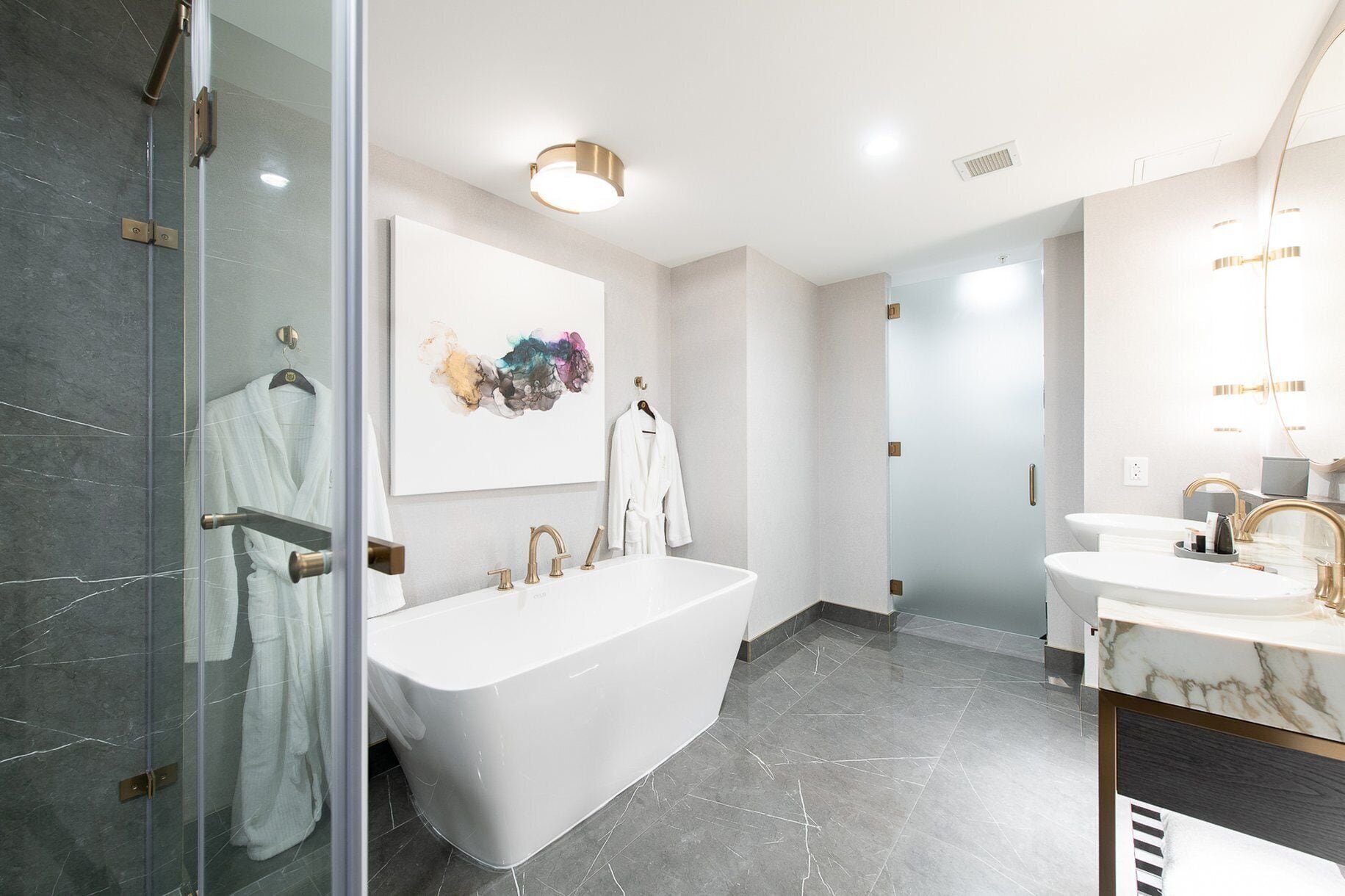 A modern bathroom with a freestanding bathtub, a large mirror, and a shower area.
