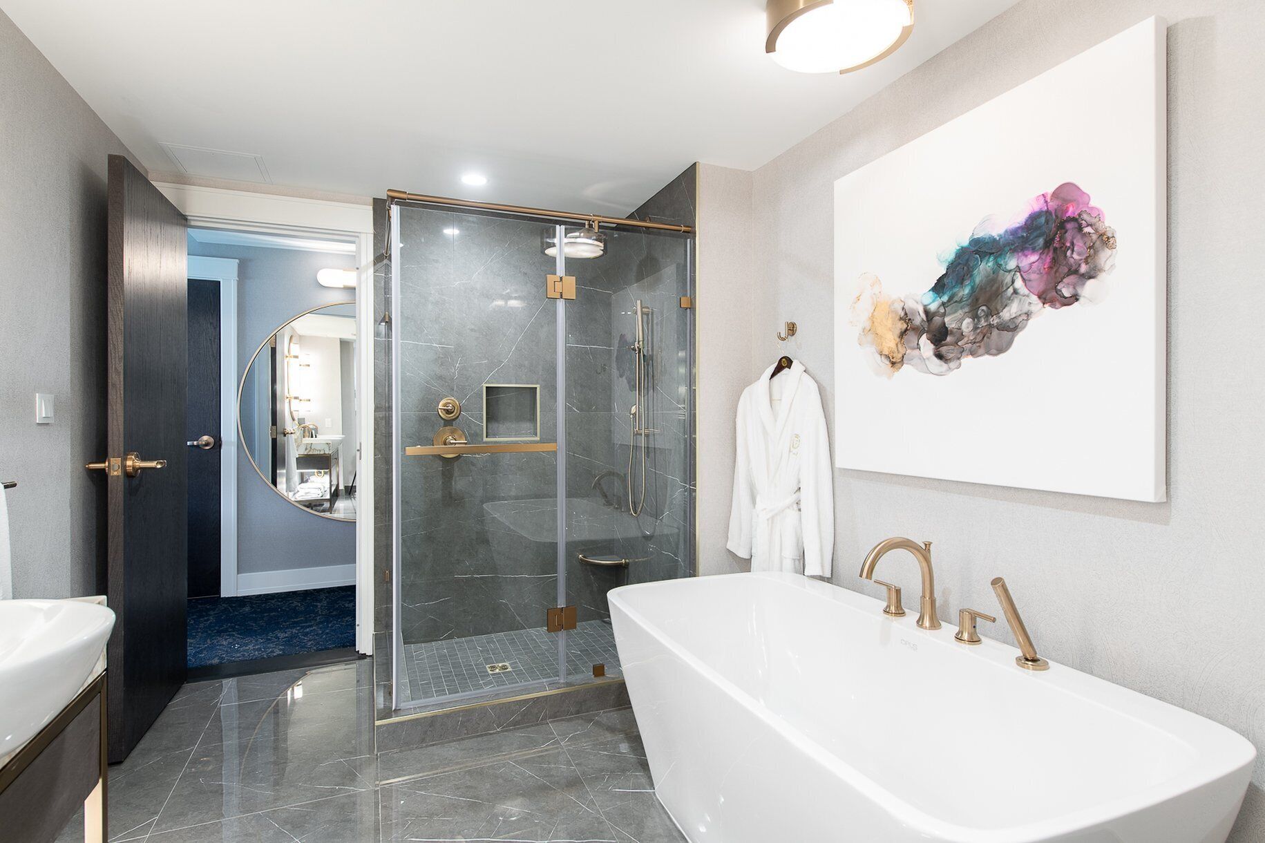 A modern bathroom with a freestanding bathtub, a glass-enclosed shower, and a large mirror.