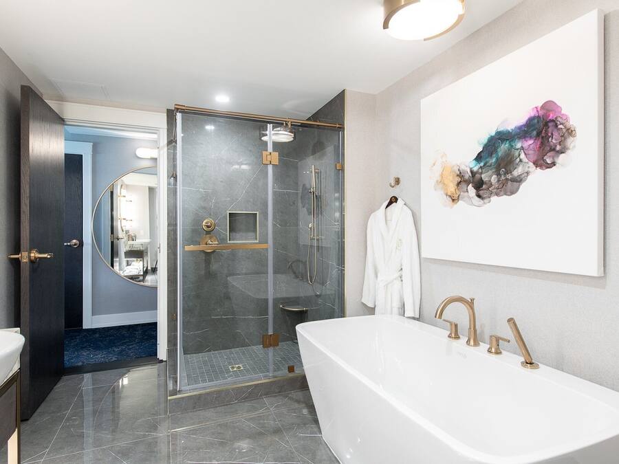 A modern bathroom with a freestanding bathtub, a glass-enclosed shower, and a large mirror.