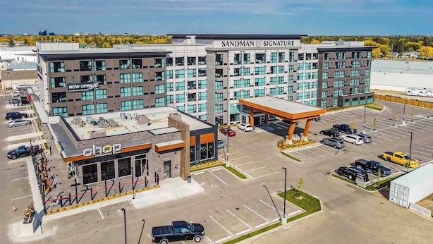 A hotel with a modern design, featuring a prominent 'Sandman Signature' sign, a parking lot, and a 'Chop Steakhouse Bar'. - Sandman Signature Saskatoon South Hotel (Saskatoon)