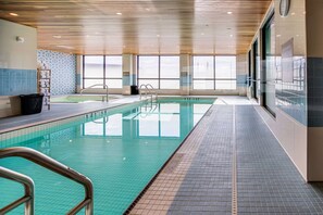 A swimming pool with clear water, tiled walls, and a wooden ceiling. - Sandman Signature Saskatoon South Hotel (Saskatoon)