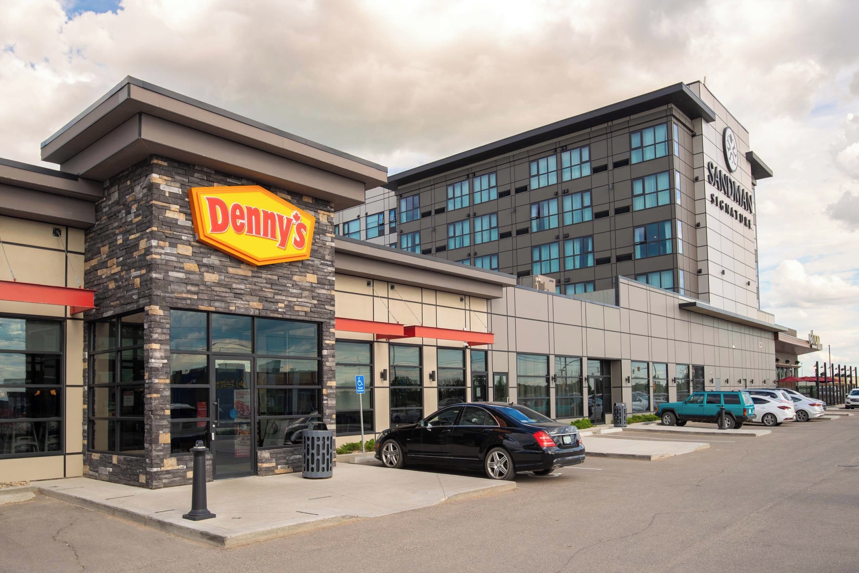 A Denny's restaurant with a stone facade and large windows.