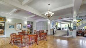 A spacious dining area with wooden chairs and a chandelier, a staircase leading to an upper level, and a view of the outdoors. - Kailua-Kona Studio - Walk to Hale Halawai Park! (Kailua-Kona)