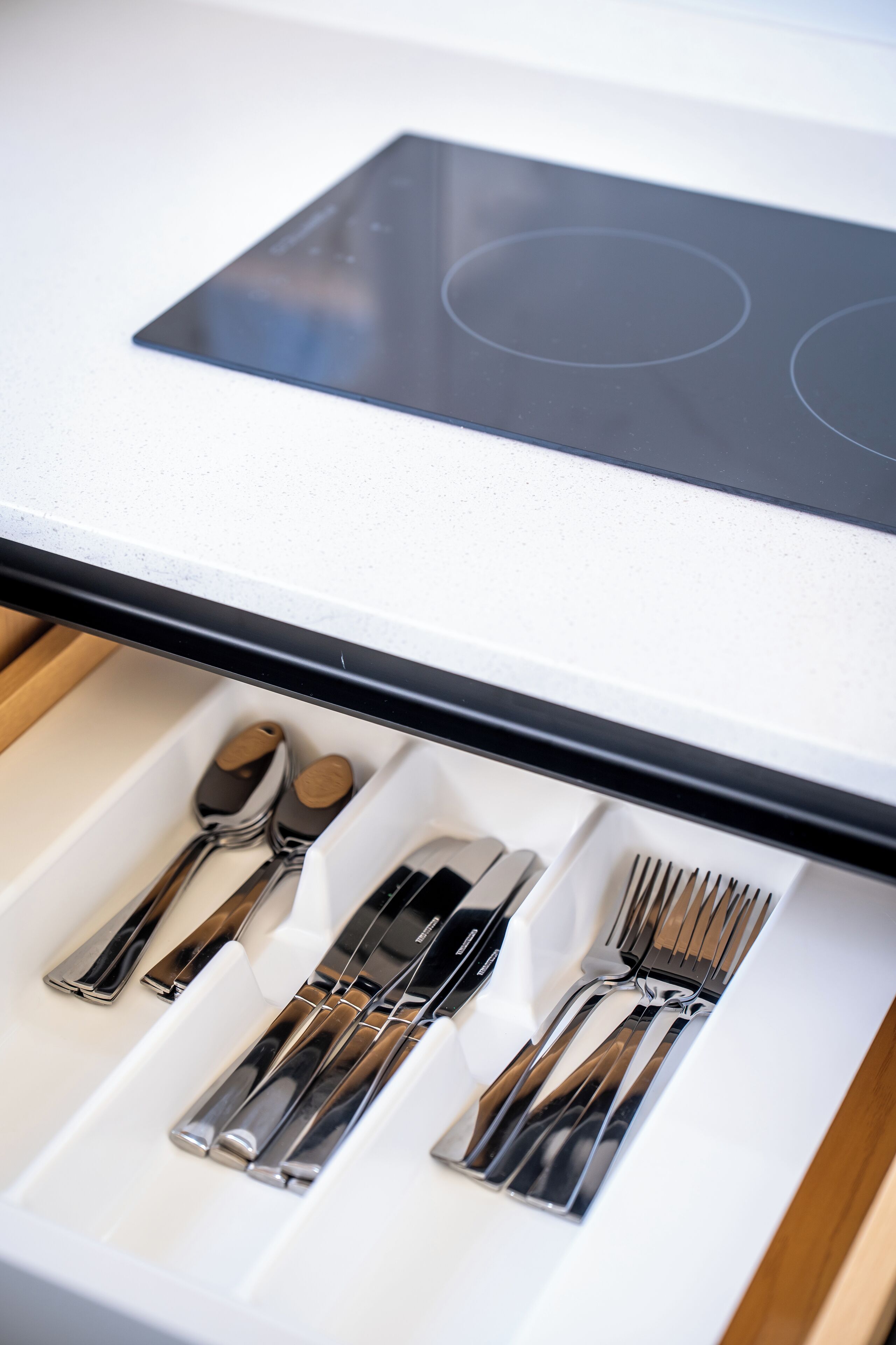 A drawer with neatly arranged cutlery including forks, knives, and spoons.