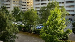 Een woongebouw met meerdere balkons en een parkeerplaats met auto's.