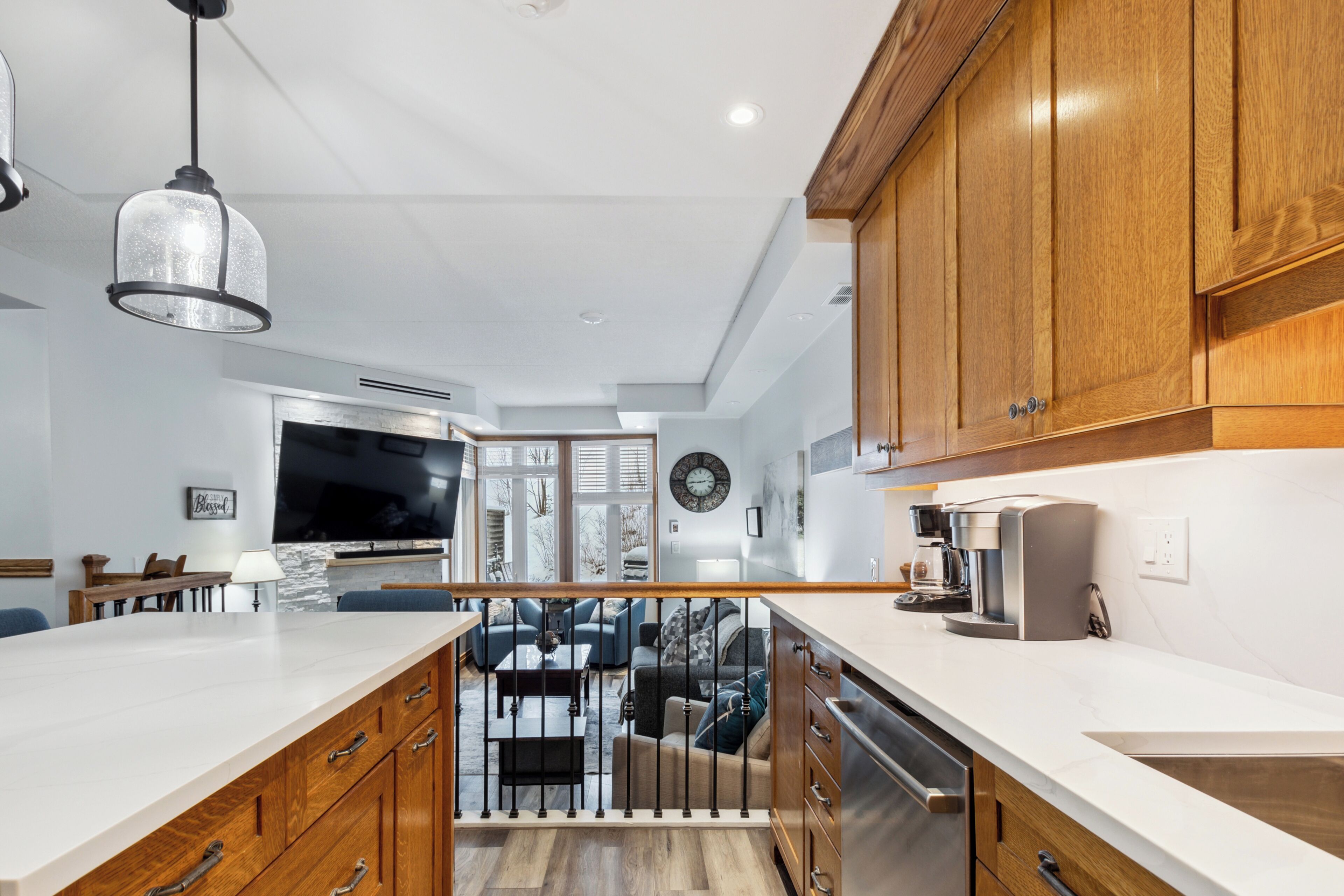 A modern kitchen with wooden cabinets, a white countertop, and a built-in oven.