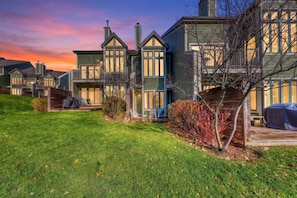 A row of houses with a grassy lawn and a wooden deck. - Chateau Ridge Chalets (The Blue Mountains)
