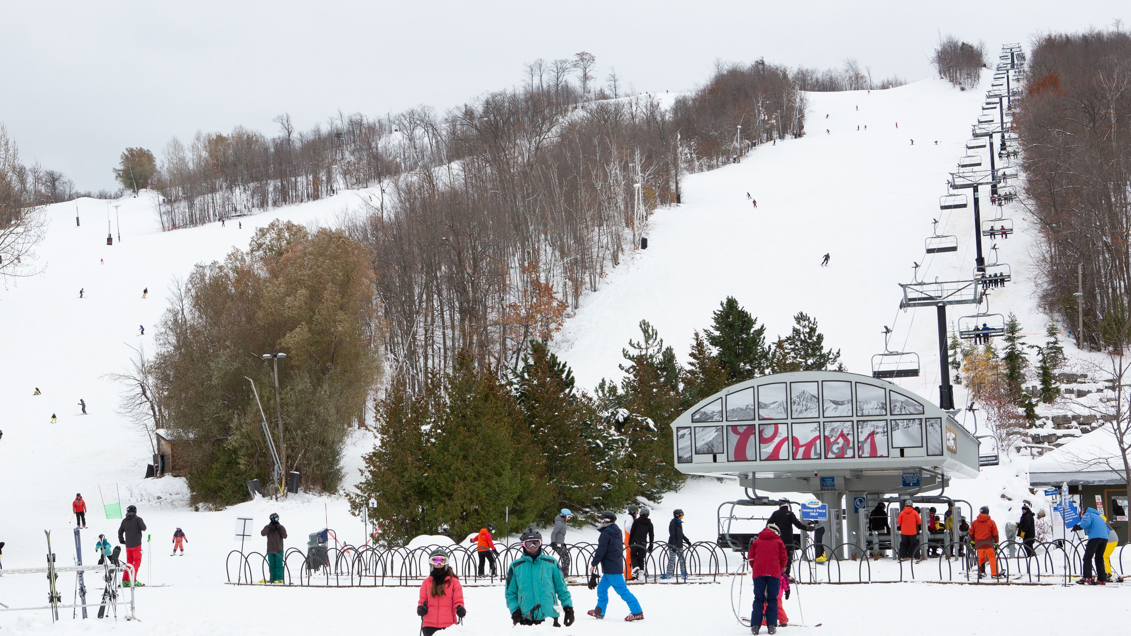 Une station de ski dotée d'un télésiège, de pistes de ski et d'un chalet.