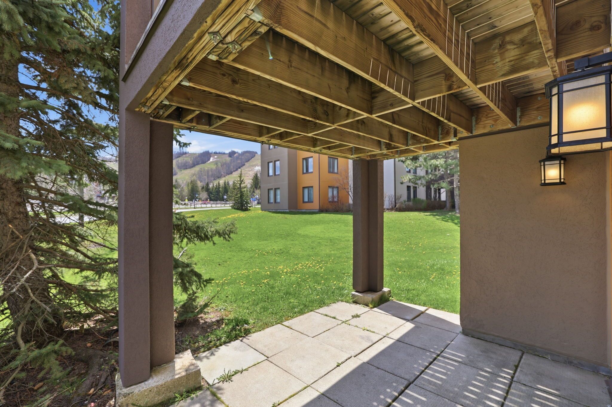 A covered outdoor area with a view of a building and mountains.
