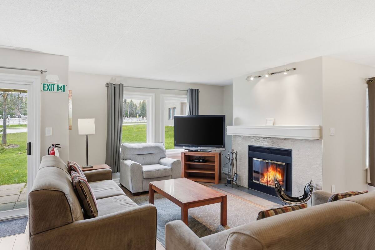 A living room with a fireplace, a television, and a sofa.