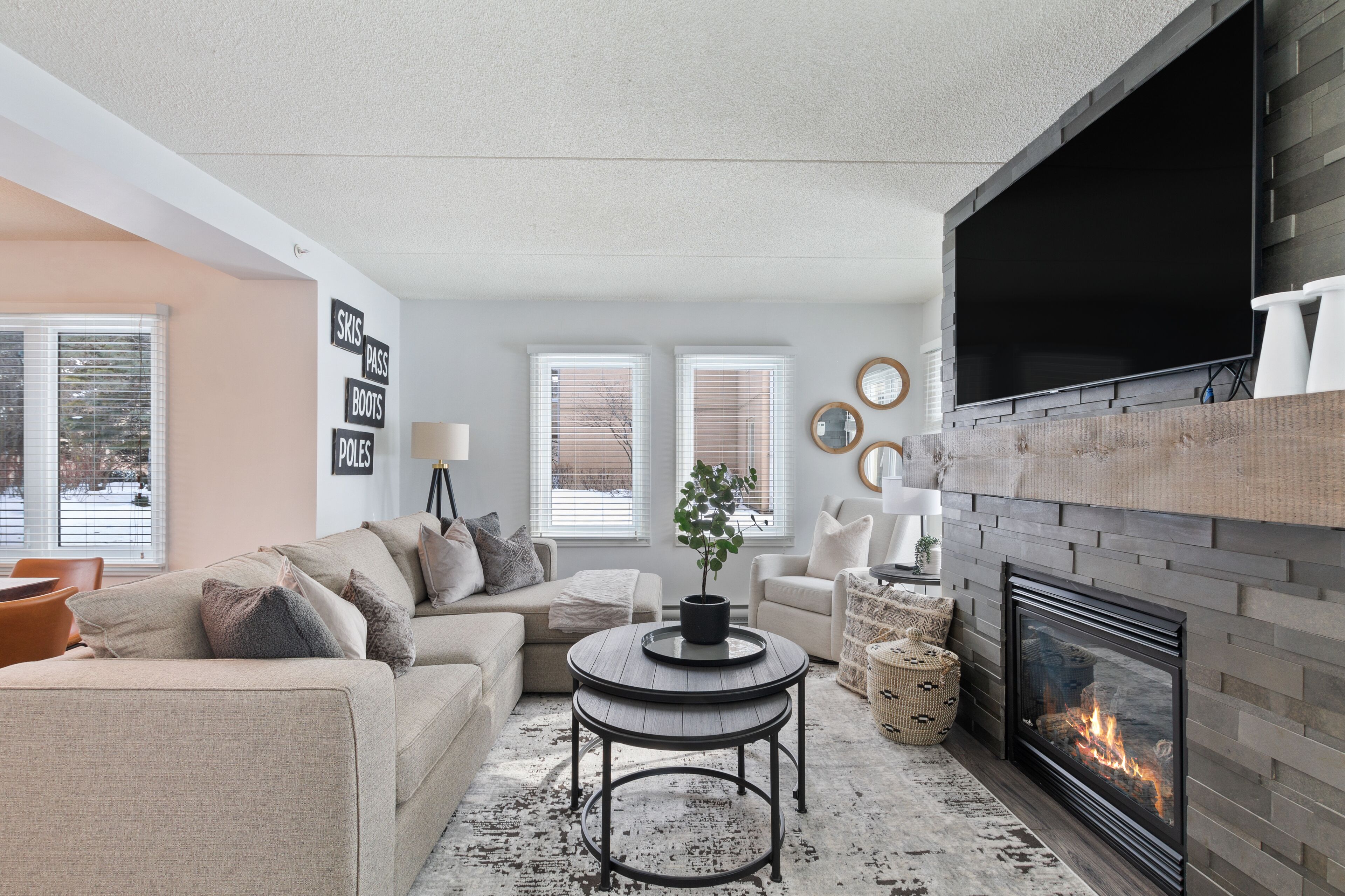 A modern living room with a fireplace, comfortable seating, and a flat-screen TV.