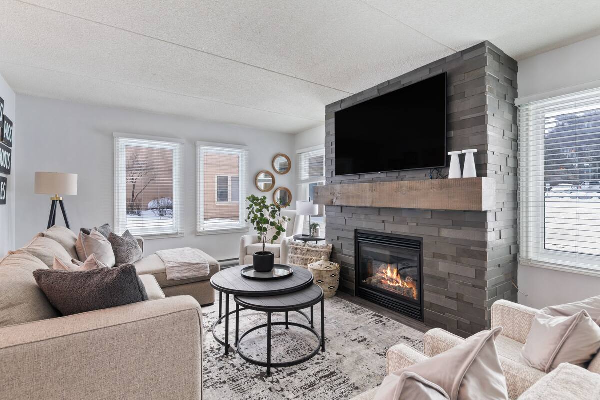 A living room with a fireplace, a flat-screen TV, and a comfortable seating area.