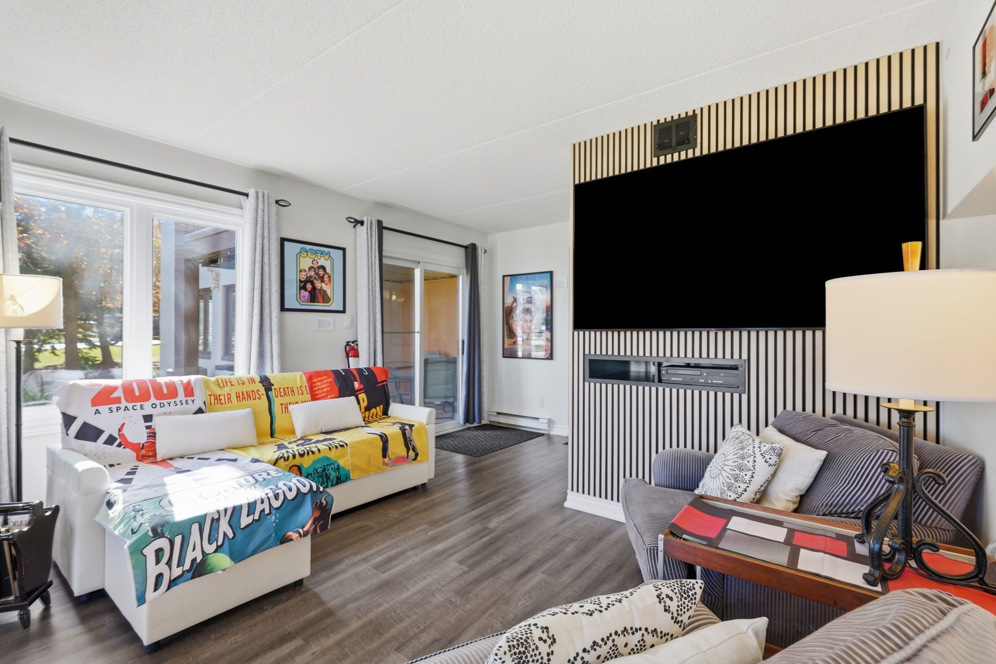 A modern living room with a sofa, a coffee table, and a TV mounted on the wall.