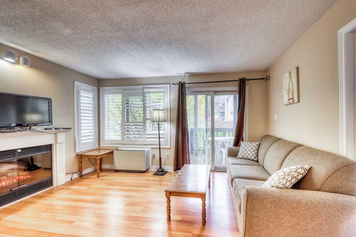 Una sala de estar con chimenea, sofá y televisor.