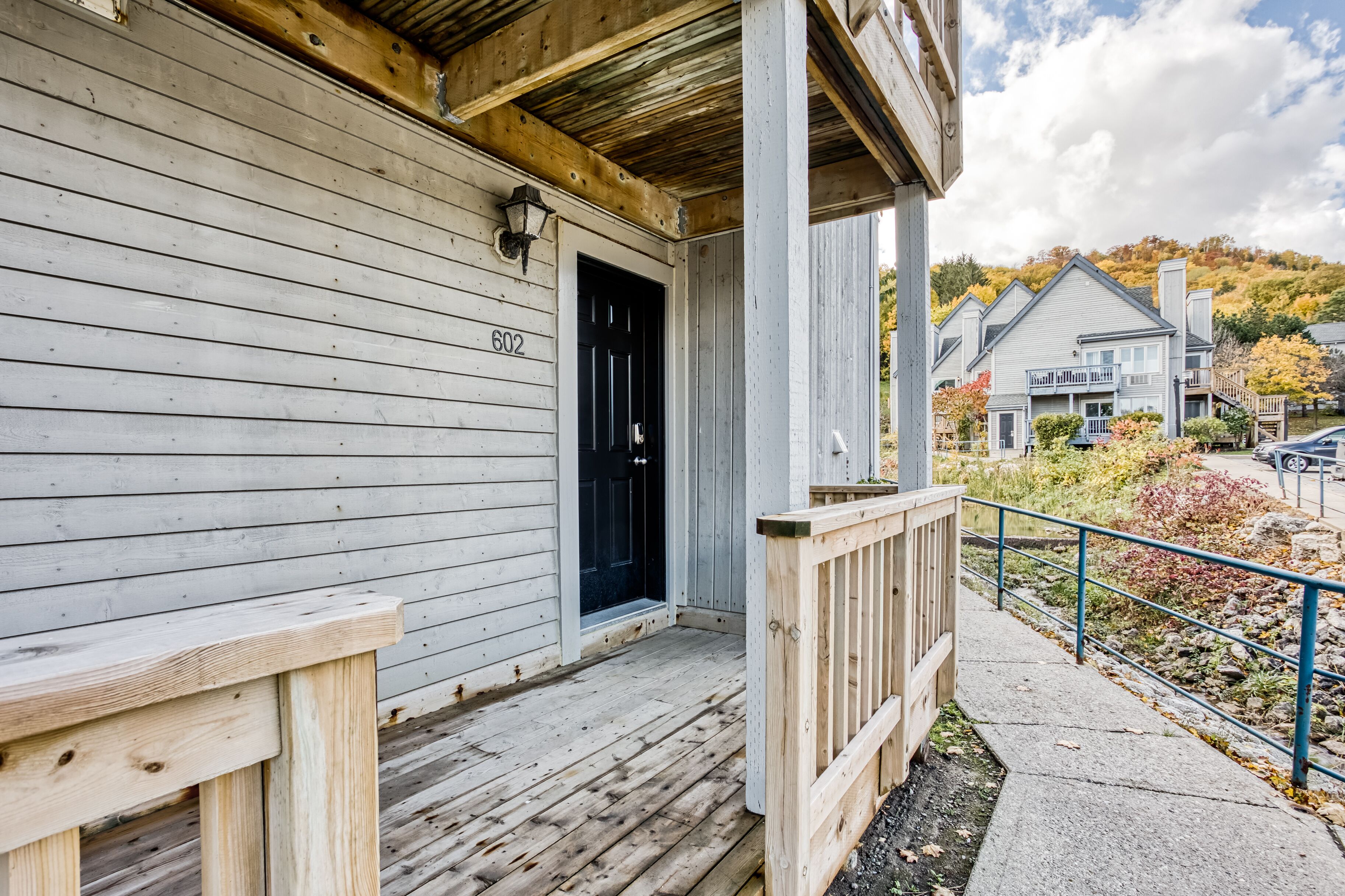 A wooden house with a black door and the number 602 on the wall.