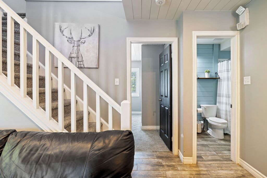A staircase leading to a bathroom with a toilet and shower curtain.