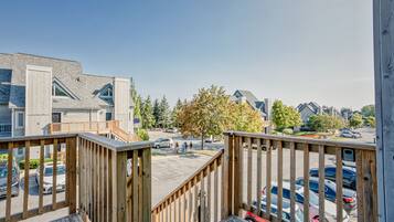 A residential area with a wooden deck, houses, and parked cars.