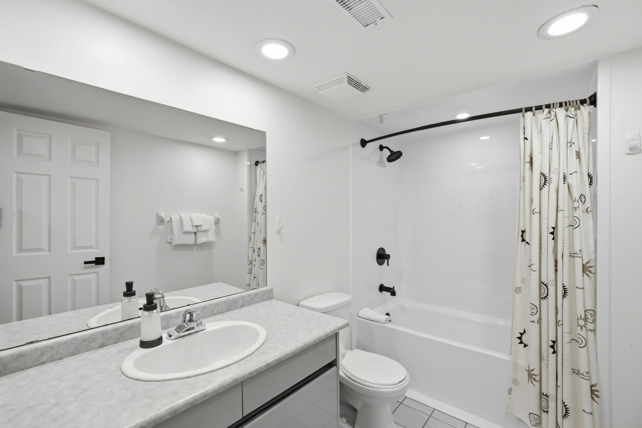 A modern bathroom with a sink, toilet, and shower.