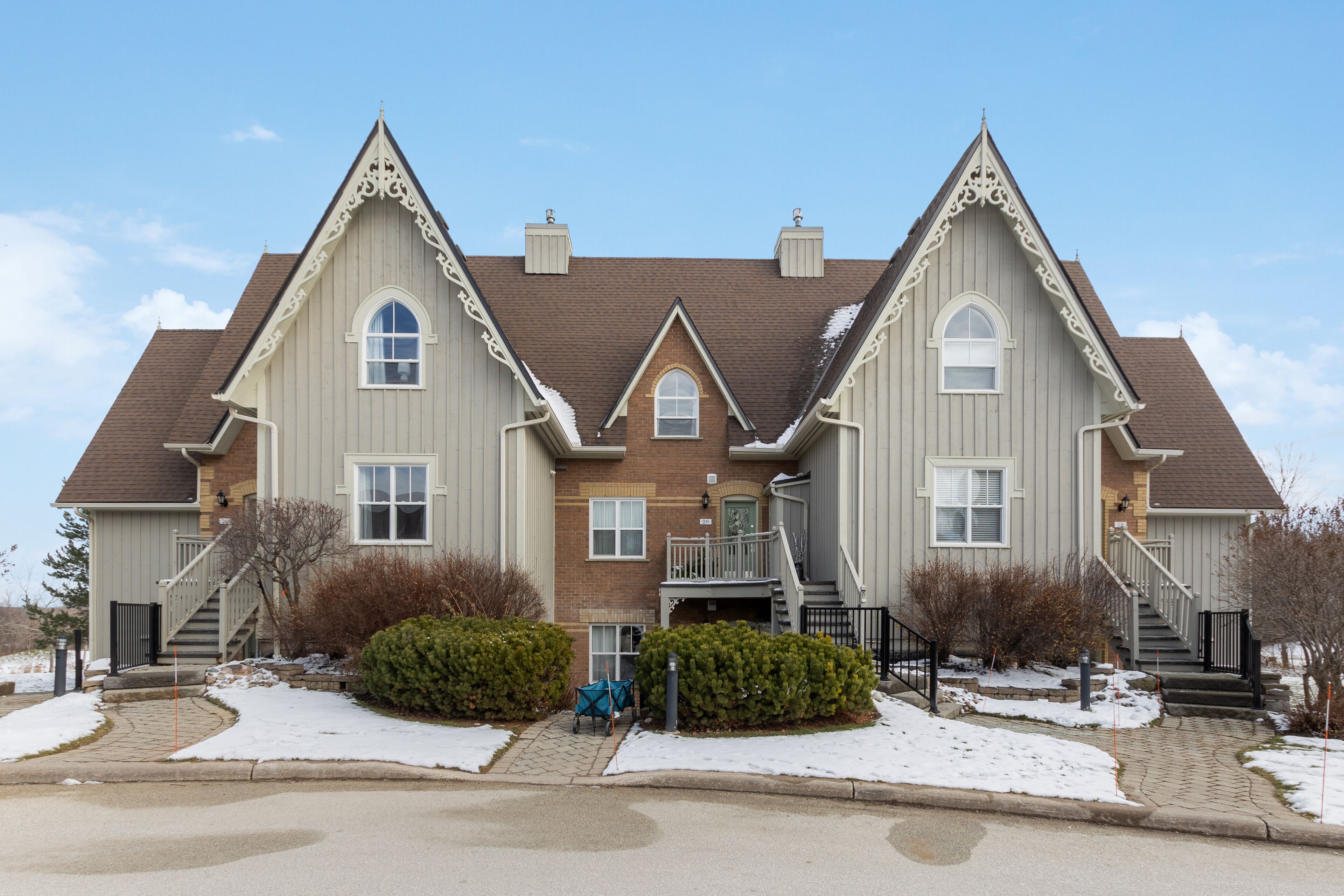 A large, two-story house with a symmetrical design, featuring a central entrance with a small porch and a staircase leading to the upper floor.
