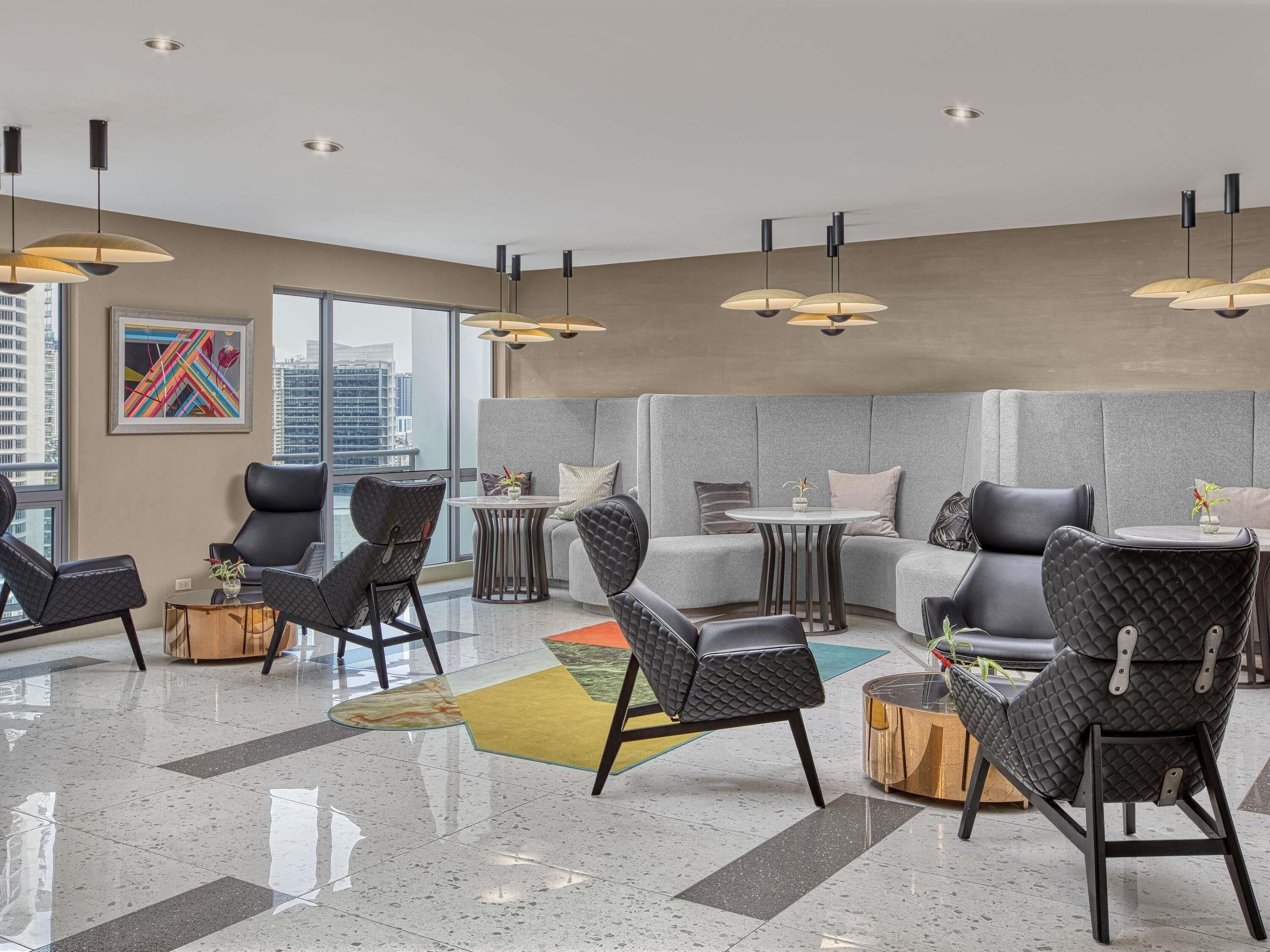 Ein stilvoller Lounge-Bereich mit Sitzgelegenheiten, einem Couchtisch und Pendelleuchten.
