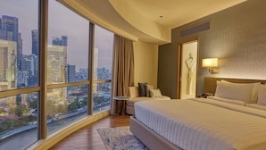 A hotel room with a large bed, a nightstand, a robe, and a view of a cityscape. - Novotel Suites Manila at Acqua (Mandaluyong)