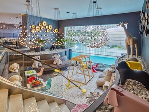 Un intérieur moderne avec une piscine, une statue de girafe et un escalier.