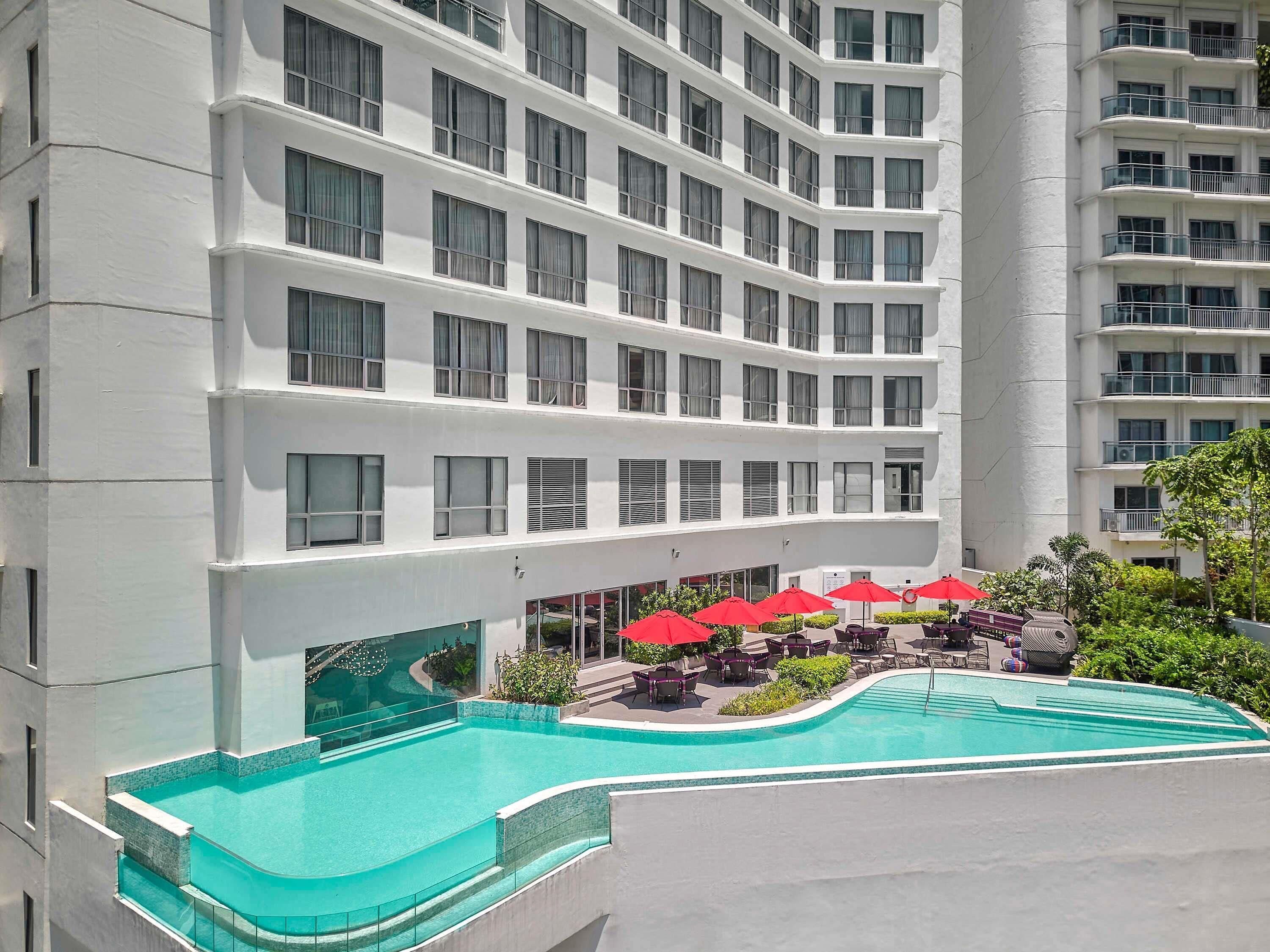 室外游泳池，06:00 至 22:00 开放，池畔遮阳伞，日光浴躺椅