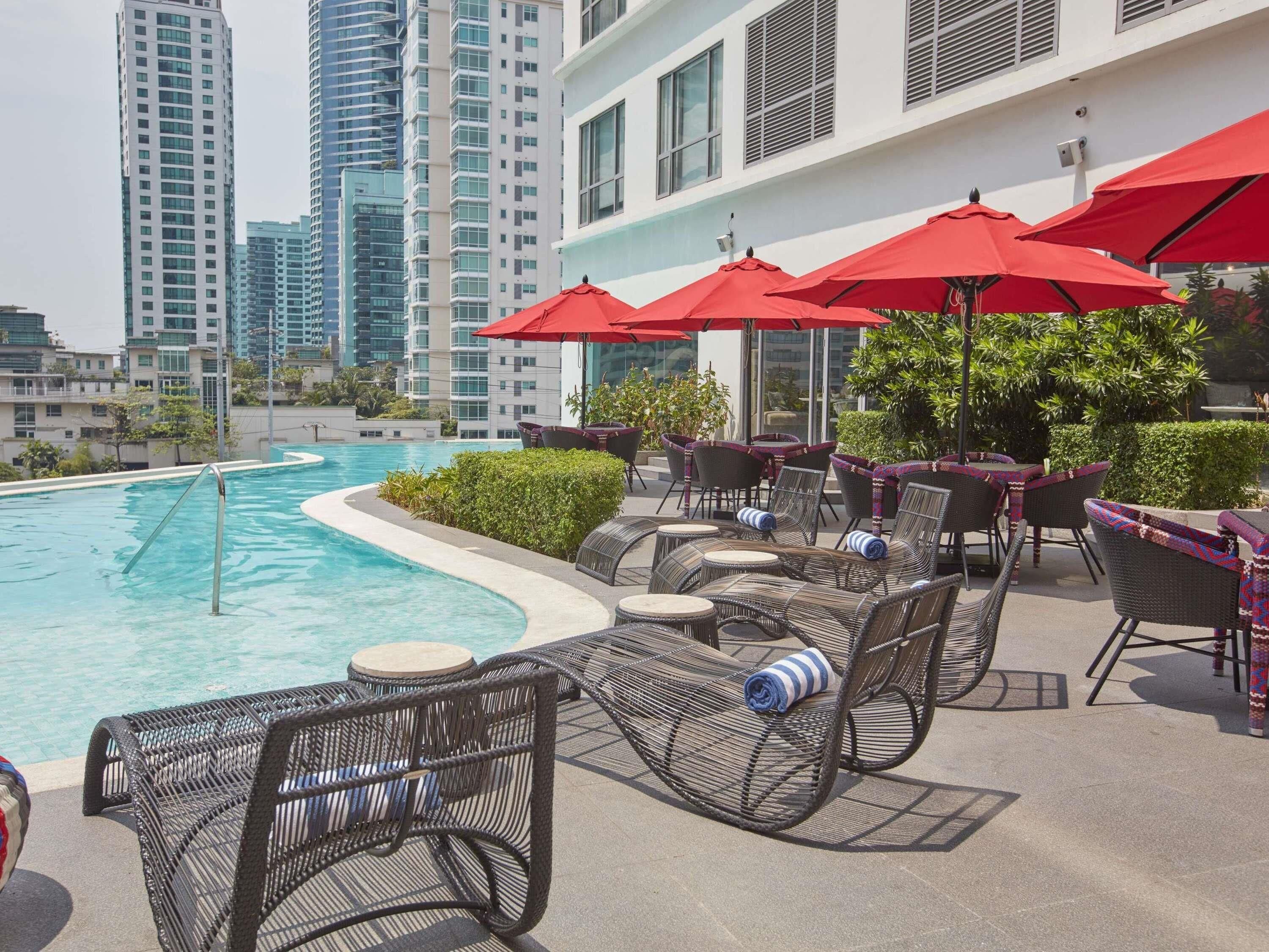 室外游泳池，開放時間為 06:00 至 22:00，提供泳池遮陽傘和日光浴躺椅