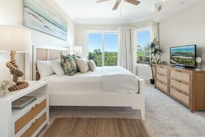 A bedroom with a bed, a TV, a desk, a window with curtains, and a ceiling fan. - Recently Updated 3 bedroom 3 bath Condo at Sanctuary at Redfish (Santa Rosa Beach)