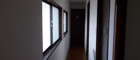 A narrow hallway with a fire extinguisher mounted on the wall.