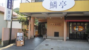A building with a sign reading "TRATTORIA" and another sign with Japanese characters. - Akitaya Annex (Kamakura)