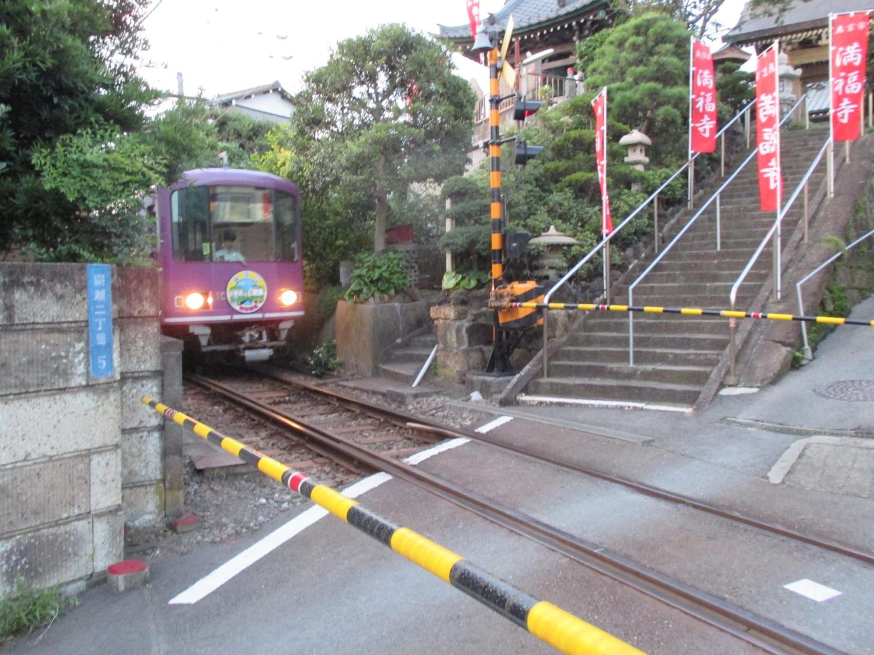 A train crossing a railway bridge with a pedestrian staircase on the right.