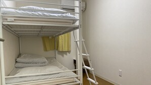 A bunk bed with a ladder, a small shelf, and a wall-mounted air conditioner. - Akitaya Annex (Kamakura)