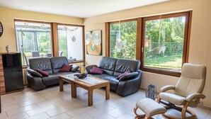 A living room with a sofa set, a rocking chair, a coffee table, and a TV stand.