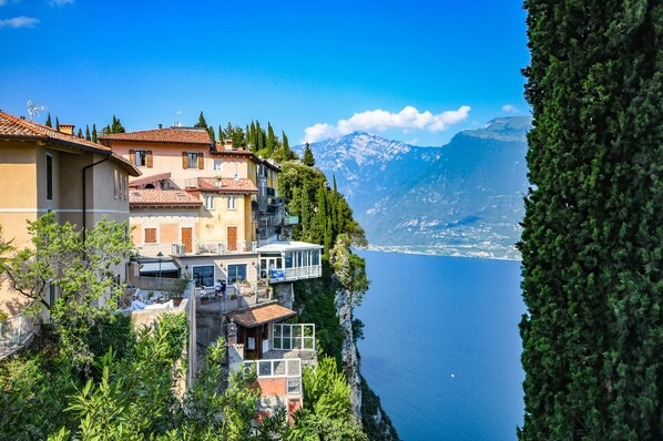 A coastal building with balconies overlooking a lake and mountains.