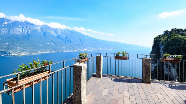 A balcony with a view of a lake and mountains. - Casa Doss Apartment with Lake View, Private Terrace, and Wi-Fi (TREMOSINE)