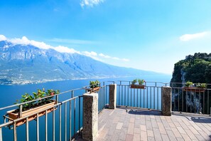 A balcony with a view of a lake and mountains. - Casa Doss Apartment with Lake View, Private Terrace, and Wi-Fi (TREMOSINE)