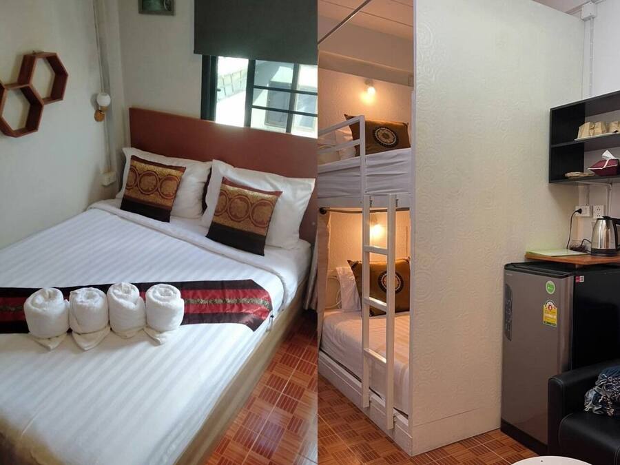 A room with a bed, a bunk bed, a small refrigerator, a table, and a wall-mounted shelf.